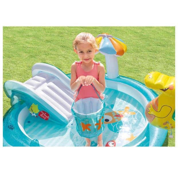 Child playing with an inflatable pool and toys on a grassy background