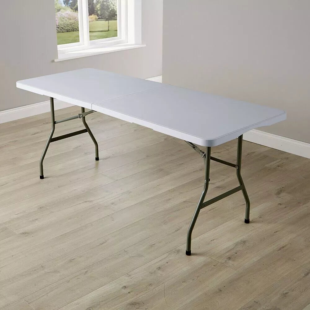 White 6ft portable folding table in an empty room with wooden floor