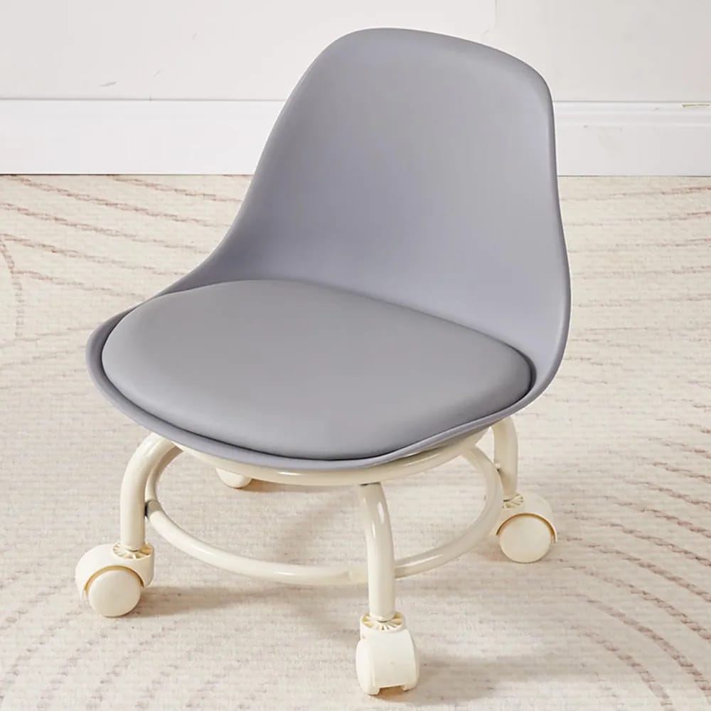 A modern gray swivel desk chair with a cream-colored metal frame and casters, set on a textured beige rug against a white wall.