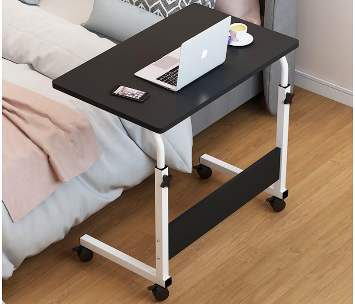 Laptop desk beside bed with cushions