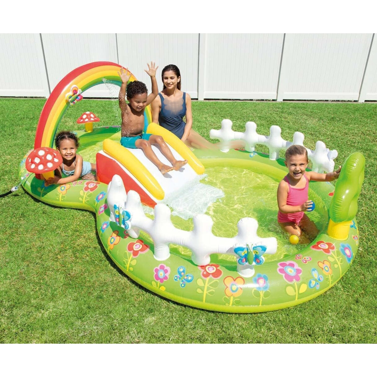 Children playing on a colorful inflatable playground set in a backyard.