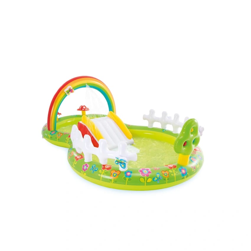 Children's inflatable play center with rainbow arch, slide, and garden-themed decorations on a white background.
