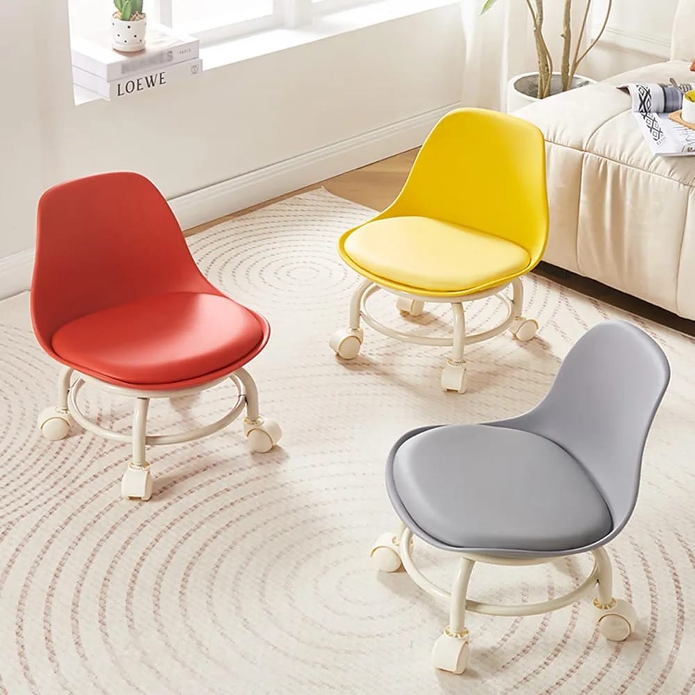 Three modern swivel chairs with rounded molded seats and white wheeled bases are arranged on a light patterned rug in a bright room. The chairs come in red, yellow, and gray colorways.