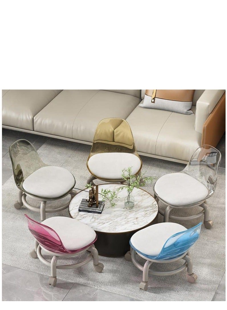 A set of five modern accent chairs arranged around a round marble-top coffee table in a living room setting with a beige sofa in the background. The chairs feature white cushioned seats and backs, clear acrylic backs, and colorful translucent shells in gold, pink, blue, and green.