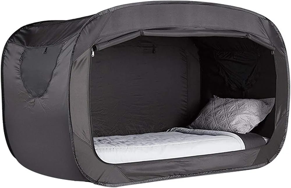 Portable pop-up bed with mattress and pillow inside a gray tent-like structure. tent house