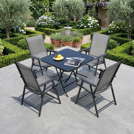 Black folding outdoor table with 4 grey sling armchairs on a garden patio in Qatar