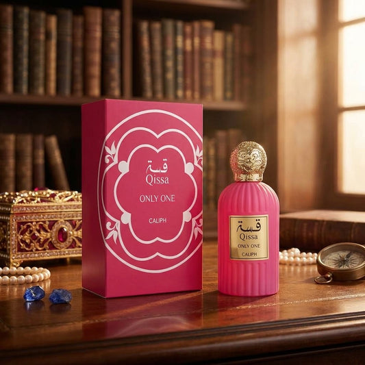 Pink Qissah Only One Calph perfume bottle and its matching pink box, styled on a wooden table with a bookshelf background.